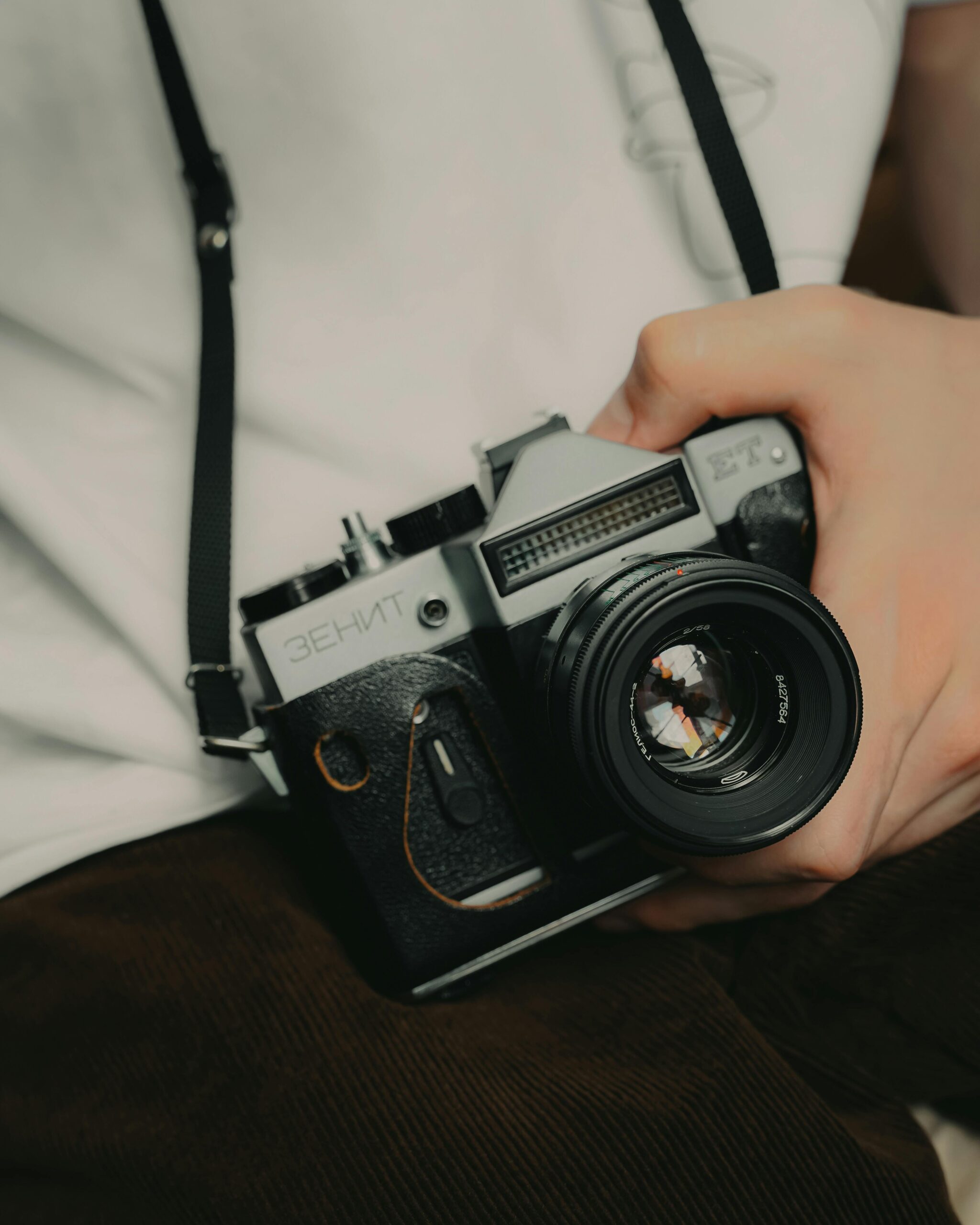 A person holding a vintage Zenit reflex camera, capturing nostalgia with a retro feel.