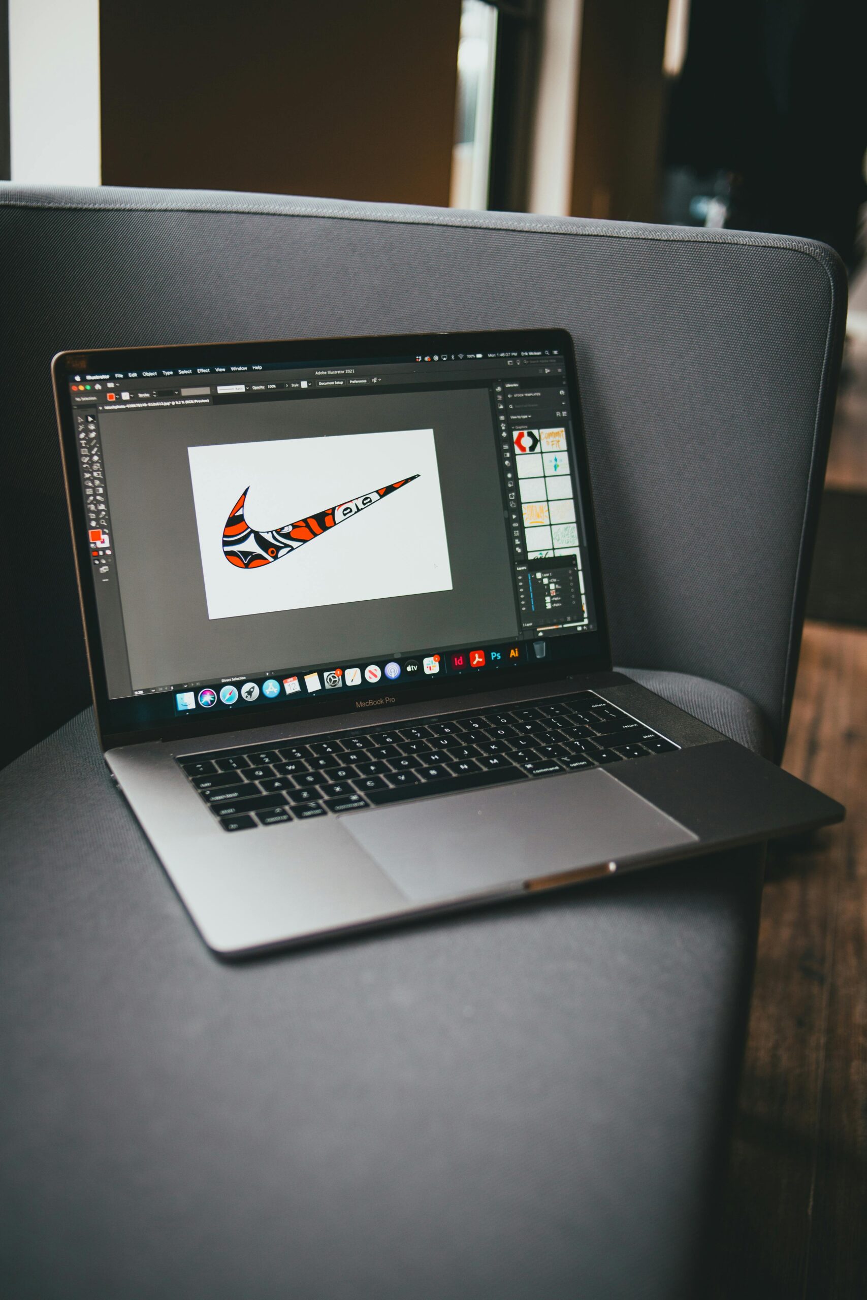 From above of modern netbook with working graphic program located on gray couch in room